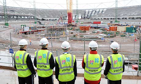 Visitors view the ongoing construction work at the Olympic stadium in east London