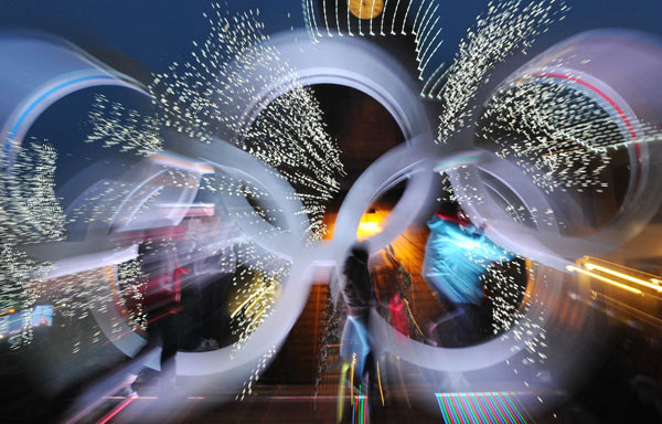 People pose in front of the Olympic rings 