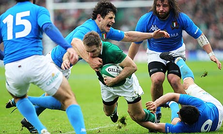 Ireland's Tomas O' Leary, center, powers his way over the line to score a try against Italy
