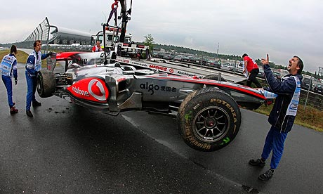 Lewis Hamilton's McLaren is lifted off the track at Hockenheim after he