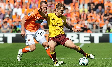 Jack Wilshere controls the ball under pressure from Charlie Adam during Arsenal's win over Blackpool