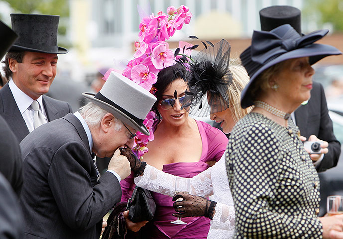 Royal Ascot Day 2: Woman is kissed on the hand as she is greeted by a friend