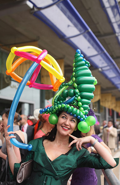 Ascot Ladies day: A racegoer with a balloon hat and umbrella poses on Ladies Day
