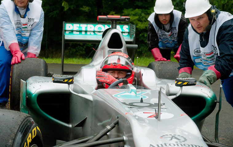 Michael Schumacher is pushed by stewards after spinning off at the Hungarian Grand Prix