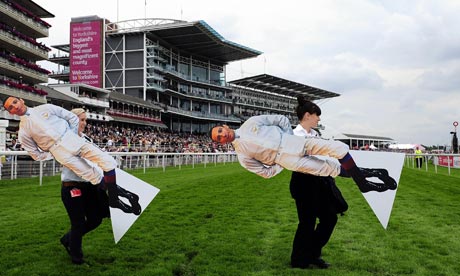 Cardboard images of Frankie Dettori are carried across York racecourse
