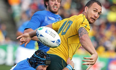 Quade Cooper is tackled by Leonardo Ghiraldini during Australia's victory over Italy in Auckland