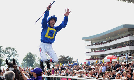 Frankie Dettori jumps off a horse in the winner's enclosure
