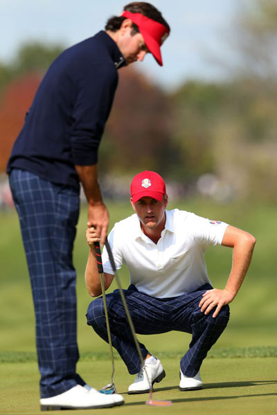 Bubba Watson and Webb Simpson of the USA work together on the 5th green