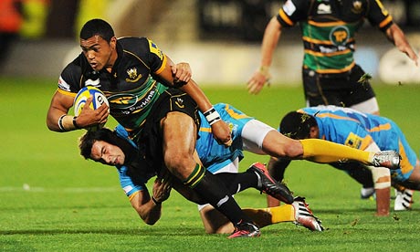 Northampton's Luther Burrell, left, looks to escape a tackle from Wasps' Nick Robinson