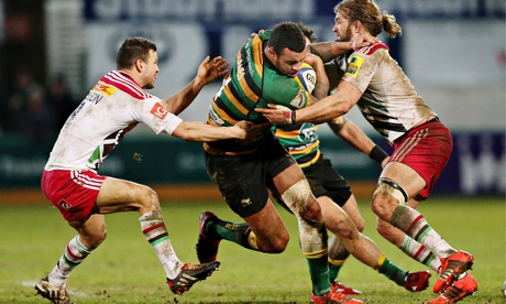 Courtney Lawes of Northampton Saints is tackled by Luke Wallace and Karl Dickson of Harlequins