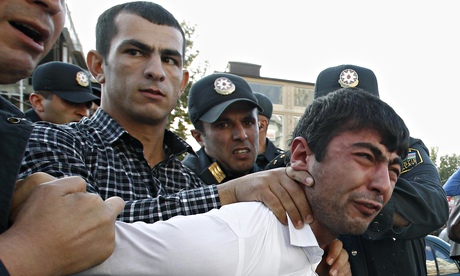 Police detain an opposition supporter in Baku