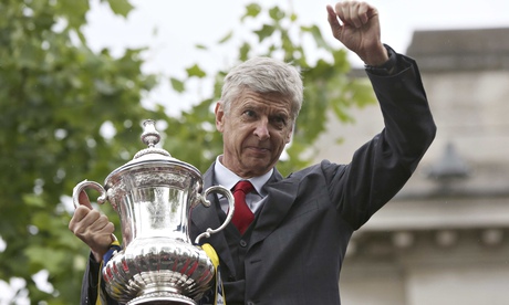 The Arsenal manager Arsene Wenger holds the FA Cup during Sunday's victory parade in north London.