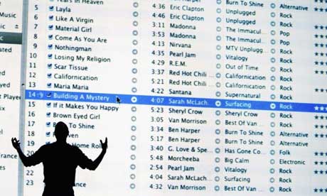 Apple CEO Steve Jobs in front of a projection of iTunes