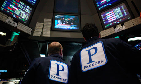 Traders work at the kiosk where Pandora is traded at the NYSE