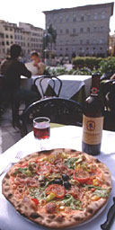 A pizza and a glass of red wine