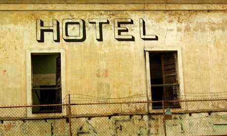 Abandoned hotel with no windows surrounded by wire fence