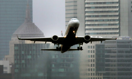 A jet takes off from Logan Airport with downtown Boston in the background.