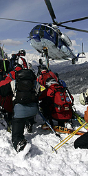 Skiers cower in the downdraft as a helicopter approaches