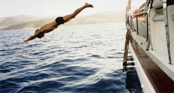 A man diving from boat in Bodrum bay