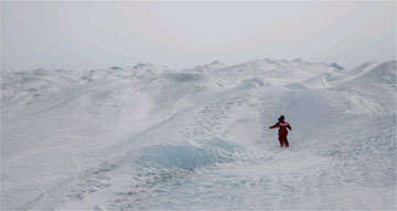 A person walking over a snow-covered Kangerlussuaq, Greenland