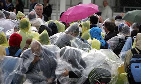 Passengers in the rain after Terminal 4 at Heathrow was evacuated after a suspect package was found, 3 July 2007