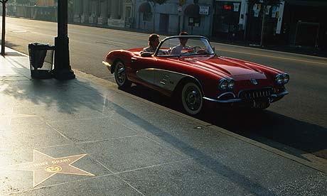 A red convertible corvette on the Hollywood Walk of Fame.