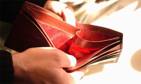 man looking at empty wallet