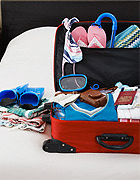Suitcase Packed with googles, bikinis and flip flops