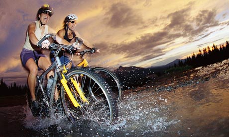 Bicyclers riding through water