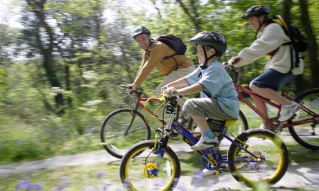 Family riding bicycles on country road