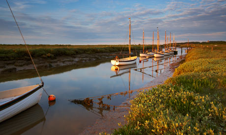 Wooden sail boats moored at Morston quay on a summer's evening in Norfolk