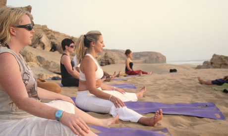 Practising yoga on the beach at sunset on the Morocco trip