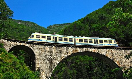 A train on the Centovalli railway crosses a viaduct in Ticino, Switzerland