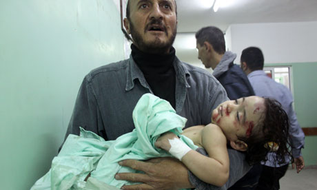 A Palestinian man carries a wounded child at a hospital following an Israeli air raid in Beit Lahia in the northern Gaza Strip, on November 17, 2012. Photograph: Moiz Salhi/AFP/Getty Images