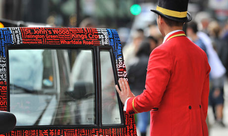A doorman closes a taxi door outside a hotel in central London