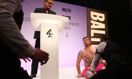 Mario Testino looks on as a streaker tries to get on stage at the 2011 Turner Prize presentation