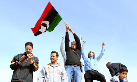 Protesters stand on a tank in Benghazi, Libya