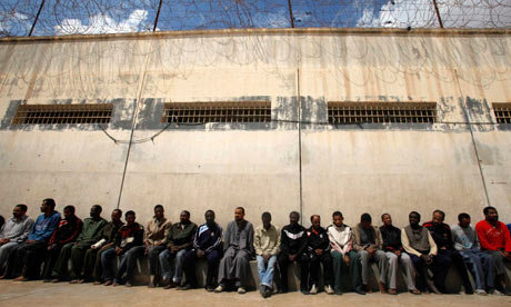 Mercenaries and forces loyal to Libyan leader Muammar Gaddafi sit inside a prison in Benghazi