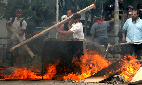 Protesters set up burning barricades to block streets leading to the parliament in Athens