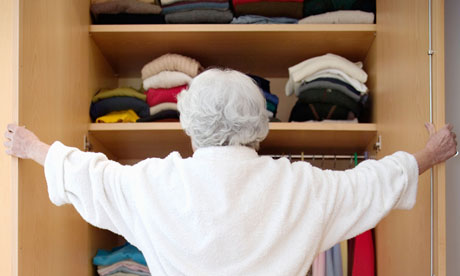 An elderly woman browsing her wardrobe