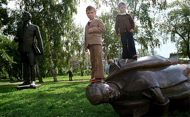 Children Standing on a fallen statue of Stalin in the Fallen Monument park, Moscow