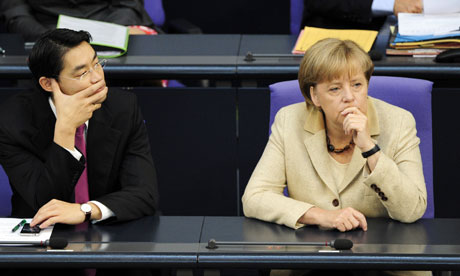 Economy Minister Philipp Roesler (L) and Chancellor Angela Merkel (R) wait at the Bundestag