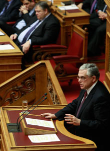 PM Papademos addresses lawmakers during a parliament session before a vote for a new austerity deal.