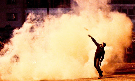 A protester throws an object back toward riot police during riots in Athens, on12 Febuary 2012.
