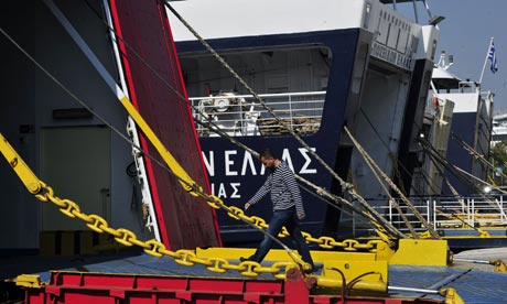 A worker walks into an anchored ferry in the harbour of Piraeus near Athens.