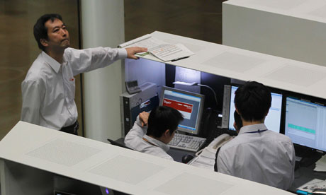 Tokyo Stock Exchange employees look at monitors at the bourse in Tokyo