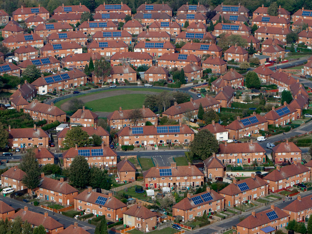 An aerial photo of a large group of homes with some featuring solar panels.