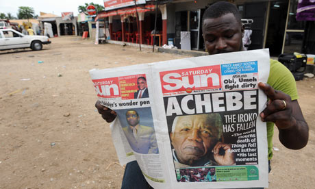 A Nigerian reads a newspaper featuring a headline on Chinua Achebe's death on 22 March