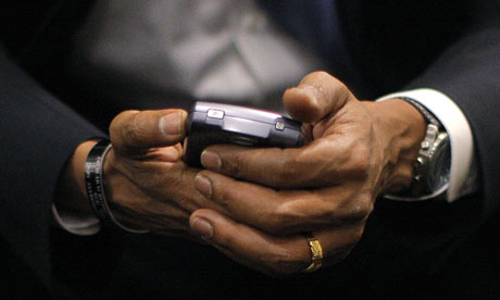 Barack Obama holds his BlackBerry 