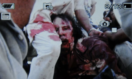 An image captured off a cellular phone camera shows the arrest of Gaddafi in Sirte